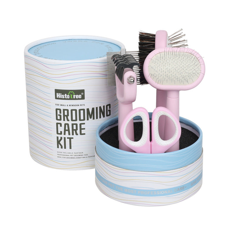 Grooming care kit with pink scissors, brush, and comb in a striped container on a white background.
